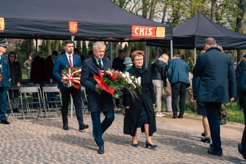 Oficjele składają kwiaty podczas obchodów upamiętniających zbrodnię katyńską w obstawie żołnierzy.
