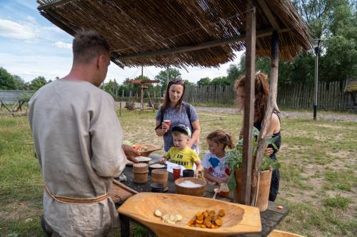 Uczestnicy przy straganie podczas degustacji.