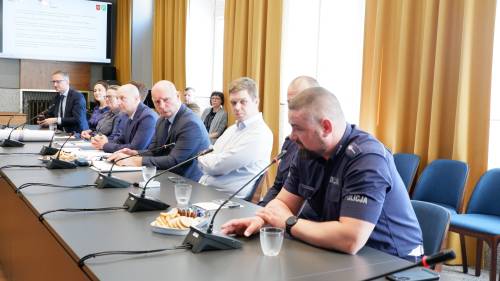 Uczestnicy spotkania, w tym przedstawiciele służb mundurowych, siedzący przy stole w trakcie rozmowy o zmianach w organizacji ruchu w mieście