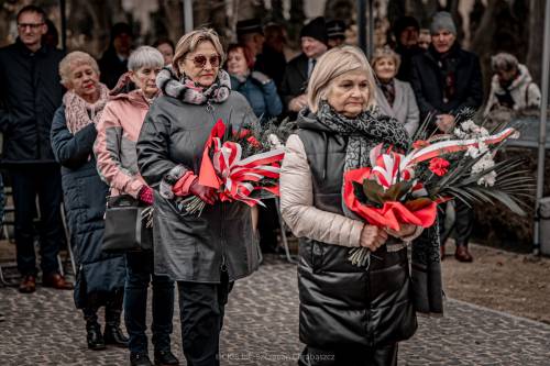 Goście składają kwiaty podczas uroczystości.