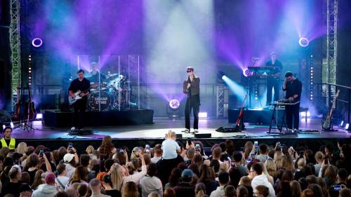 Koncert Oskara Cymsa, na scenie artysta z muzykami, przed sceną licznie zgromadzona publiczność