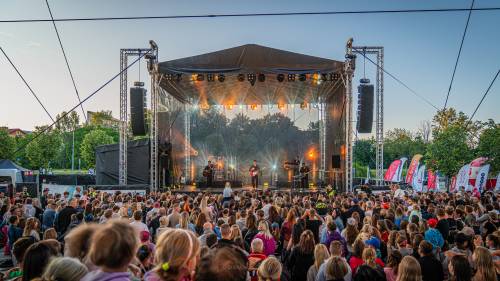 Scena muzyczna na Faktorii, na scenie Oskar Cyms z muzykami, przed sceną licznie zgromadzona publiczność