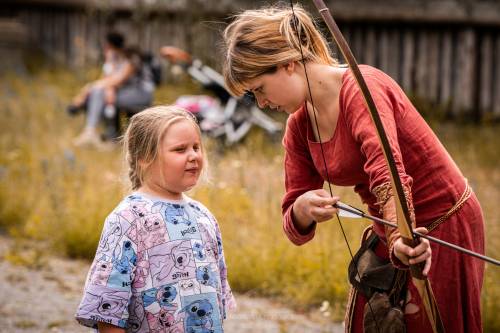 Dziewczynka przygląda się, jak wygląda próba strzelenia z łuku