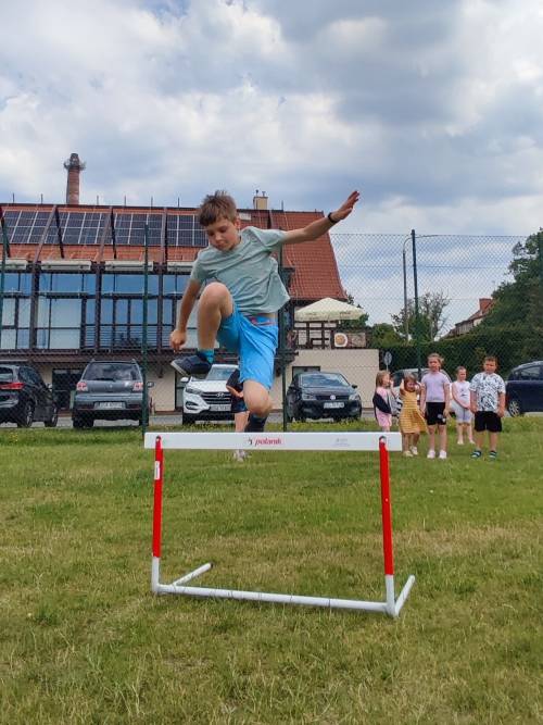Zabawy na świeżym powietrzu, chłopiec skacze przez bramkę