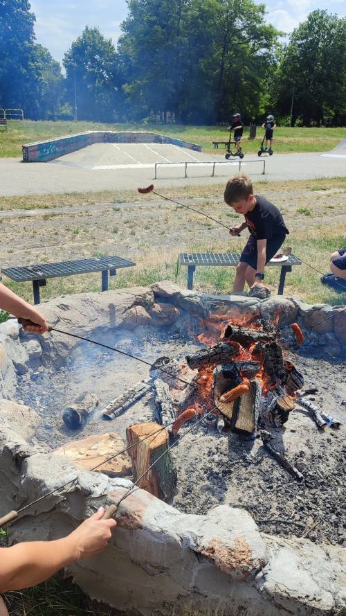 Ognisko, dzieci pieką kiełbaski