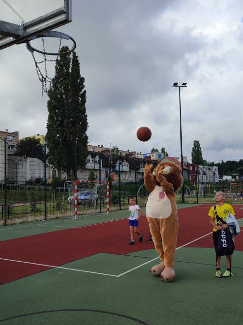 Lew Pruszek próbuje wrzucić piłkę do kosza