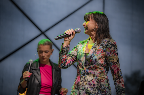 Krystyna Giżowska z mikrofonem w ręce, na dalszym planie druga artystka