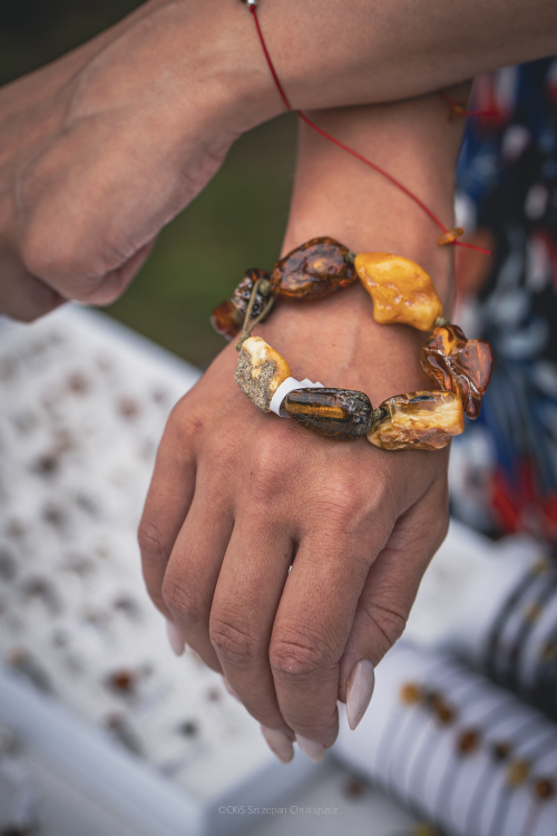 Jarmark w Parku Kulturowym Faktoria, na zdjęciu na ręce widoczna bransoletka, rękodzieło z dużymi bursztynami